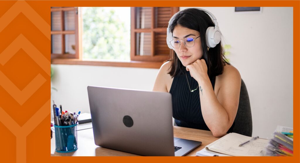 Person sitting at a laptop working with headphones on