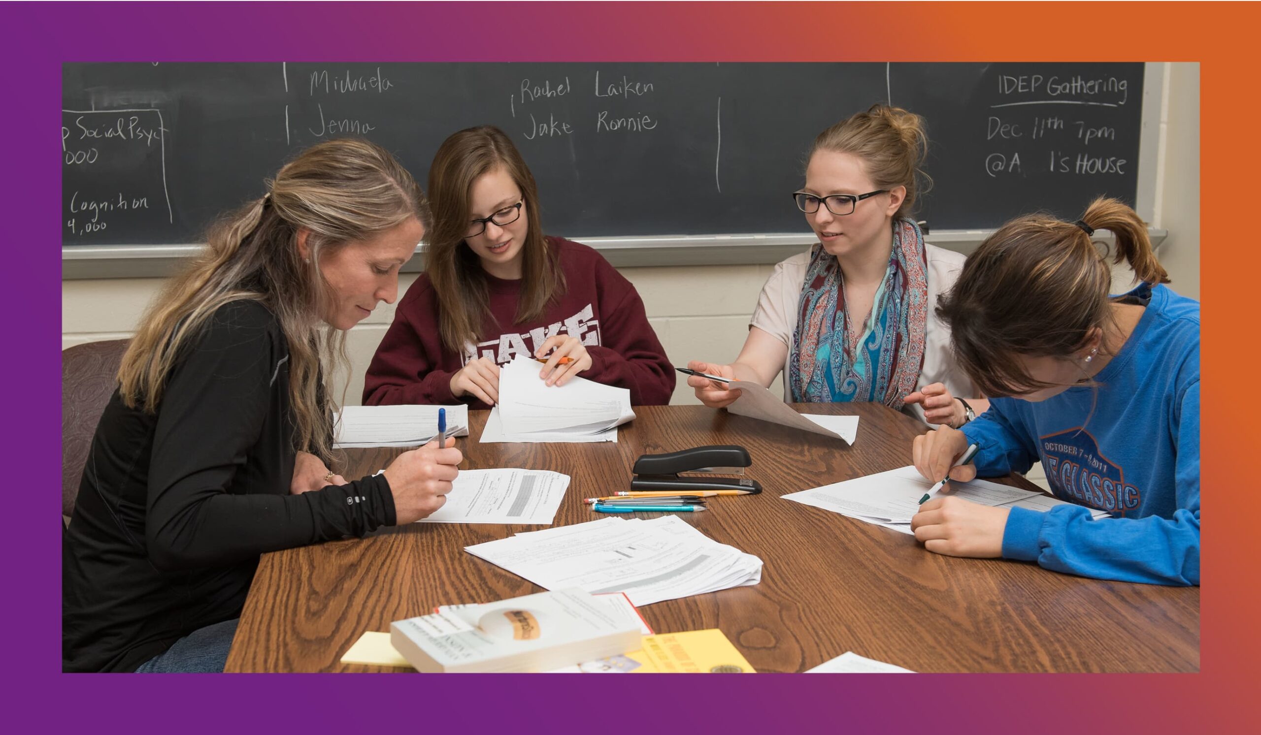 People sitting around a table looking at papers and writing