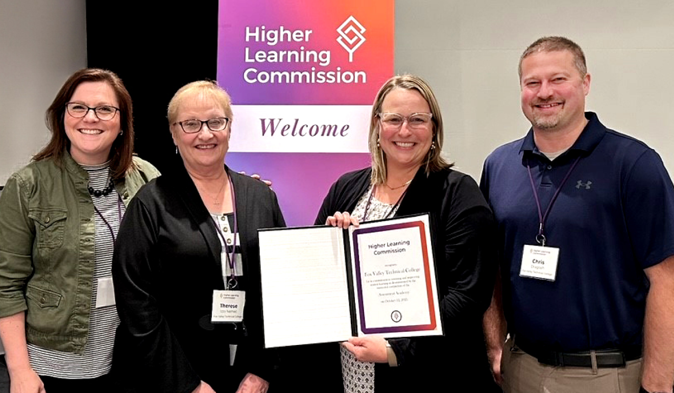 People holding up an HLC Assessment Academy completion certificate