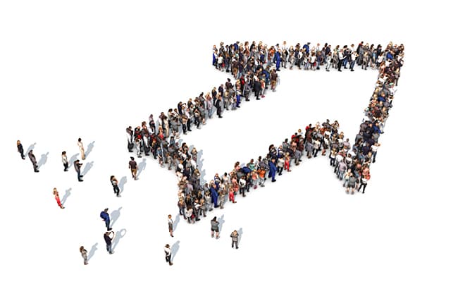 A crowd of people standing in the shape of an arrow pointing up and to the right